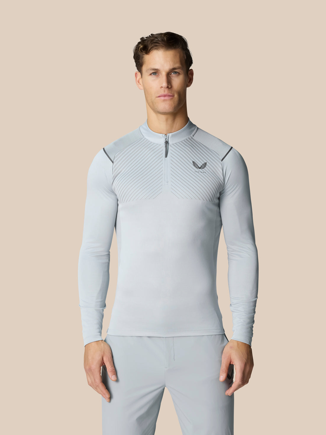 Men's light grey Pinnacle LVS quarter zip top with diagonal stripe pattern and Castore logo on left chest