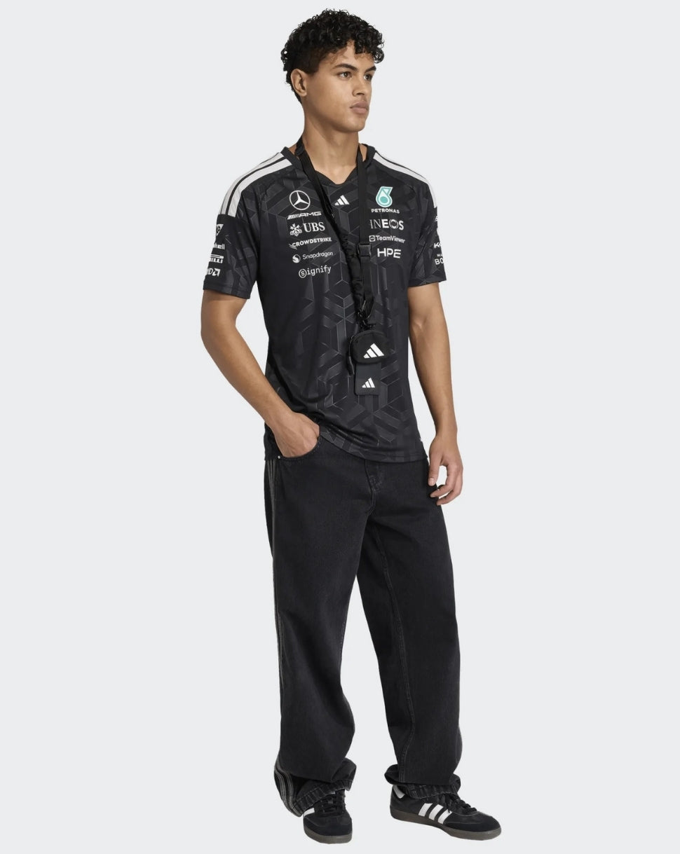 Male model wearing black Mercedes AMG Petronas F1 Team driver T shirt with sponsor logos and white shoulder stripes