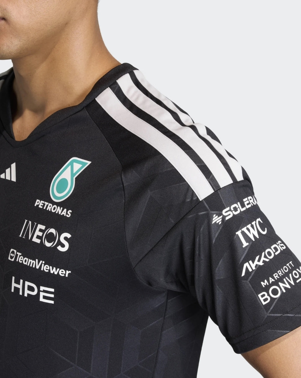 Chest view of black Mercedes AMG Petronas driver T shirt featuring teal Petronas logo and multiple sponsor badges