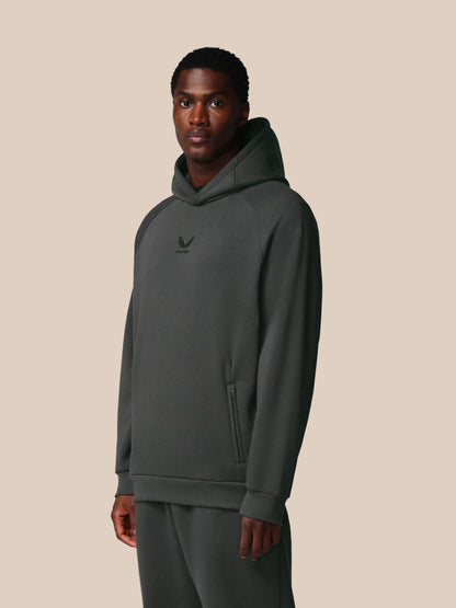 Man wearing a gray hoodie with a logo on a beige background