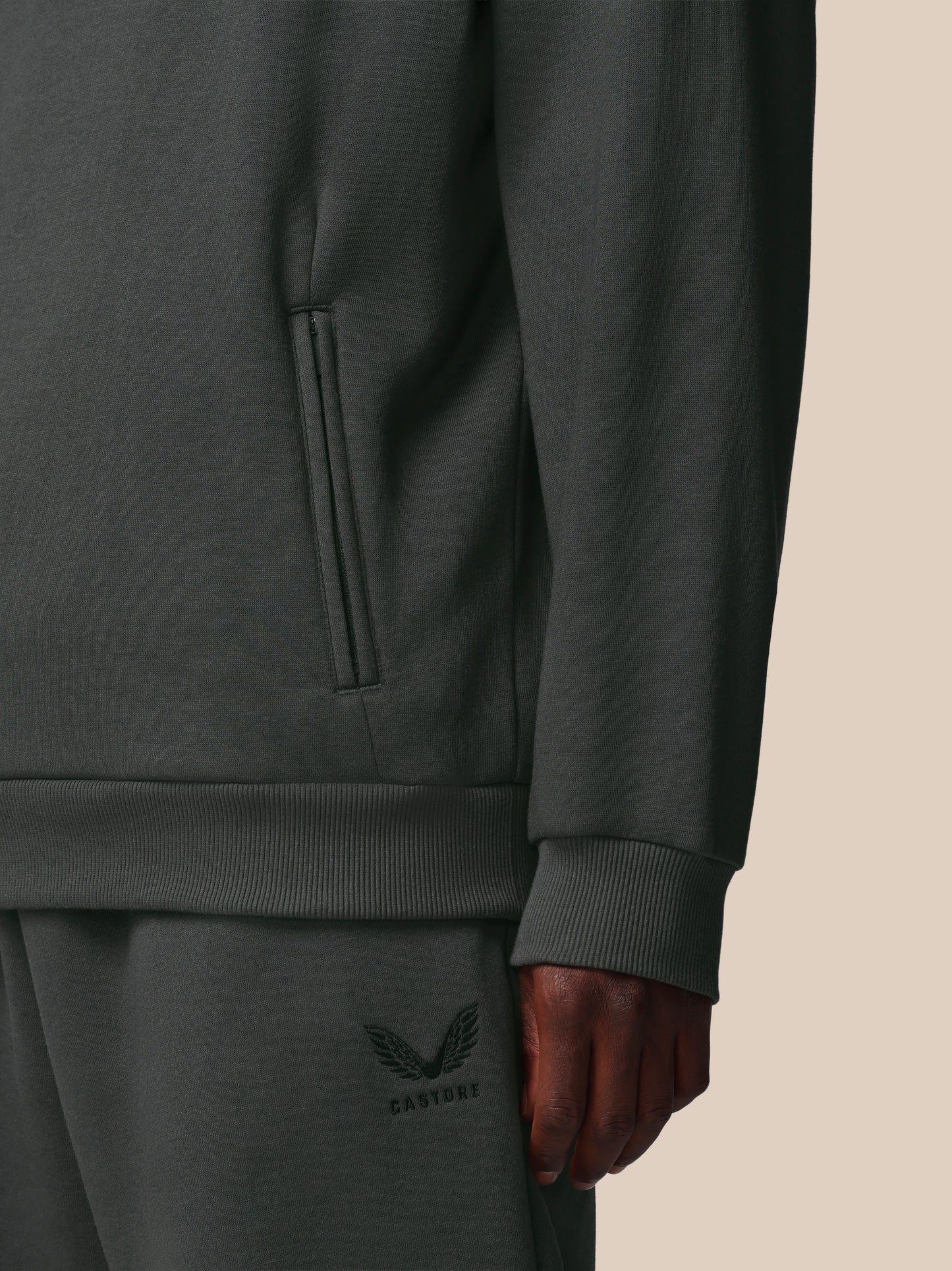 Dark gray sweatshirt with a brand logo on a beige background