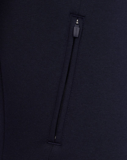 Close-up of a navy blue garment with a zipper detail on a matching background