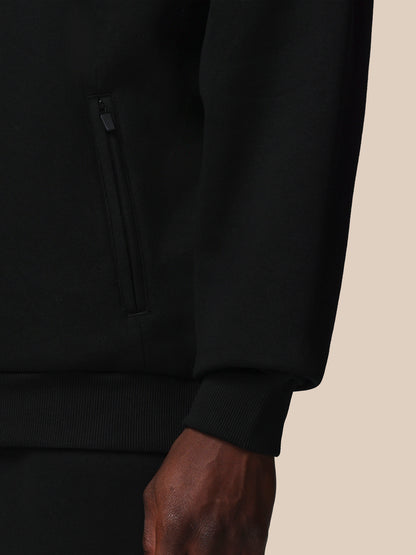 Close-up of a black hoodie on a beige background