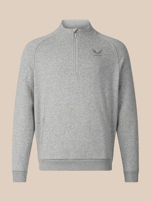 A light gray heathered quarter-zip sweatshirt with a small dark gray embroidered logo on the left chest, displayed on a solid beige background.