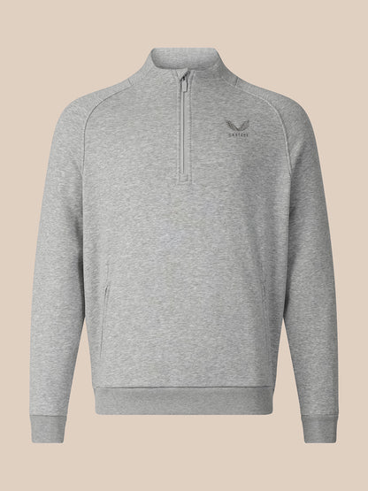 A light gray heathered quarter-zip sweatshirt with a small dark gray embroidered logo on the left chest, displayed on a solid beige background.