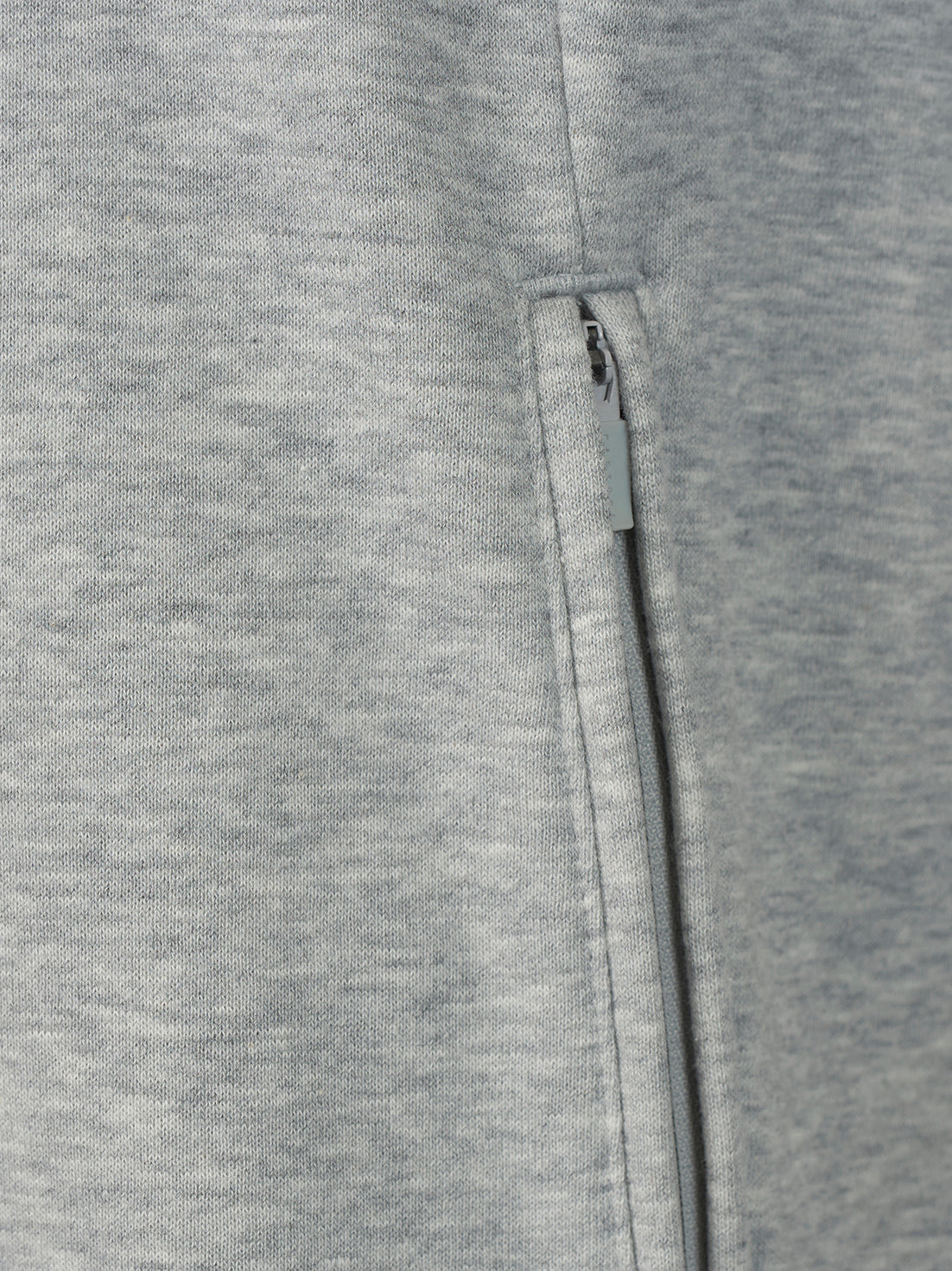 Close-up of a heather gray fabric garment showing a vertical zipper detail.