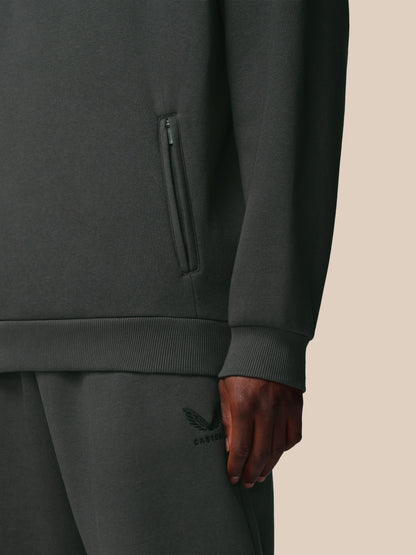 Dark gray tracksuit with a visible brand logo on a beige background