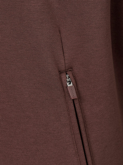 Close-up of a dark brown ribbed knit garment featuring a vertical zippered pocket with a matching brown pull tab.