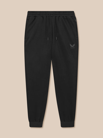 Black jogger pants with a logo on a beige background