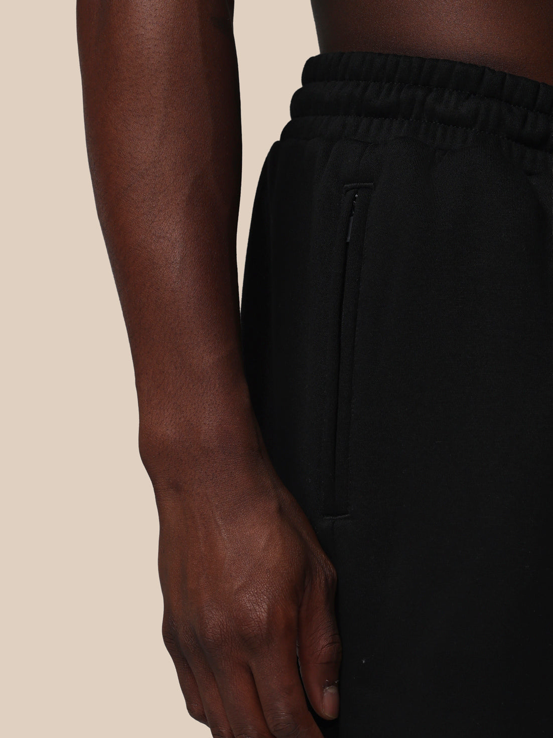 Person wearing black pants with a neutral background