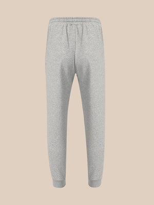 Light gray heather sweatpants with an elastic waistband and ribbed ankle cuffs, shown against a solid beige background.