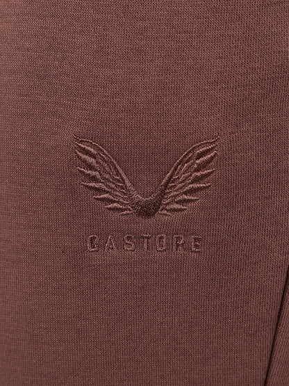Close-up of a brown textured knit fabric with an embossed winged logo and the word 'CASTORE' centered on the chest.