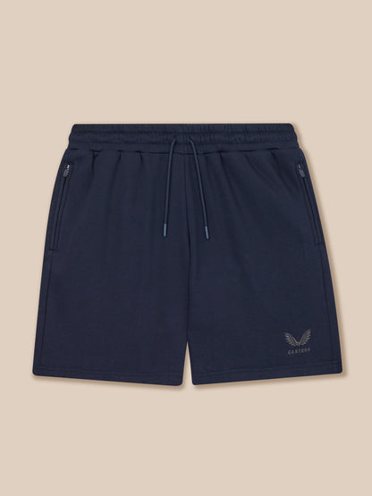 Navy blue shorts with a brand logo on a beige background