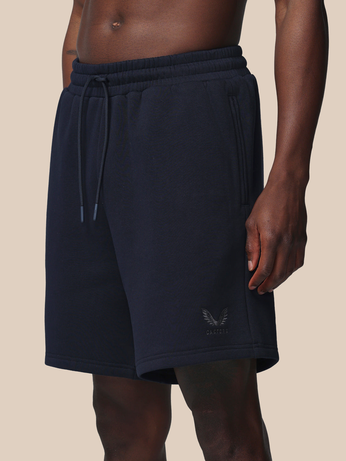 Navy blue shorts with drawstring on a beige background