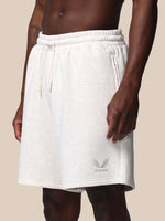 White shorts worn by a person on a beige background