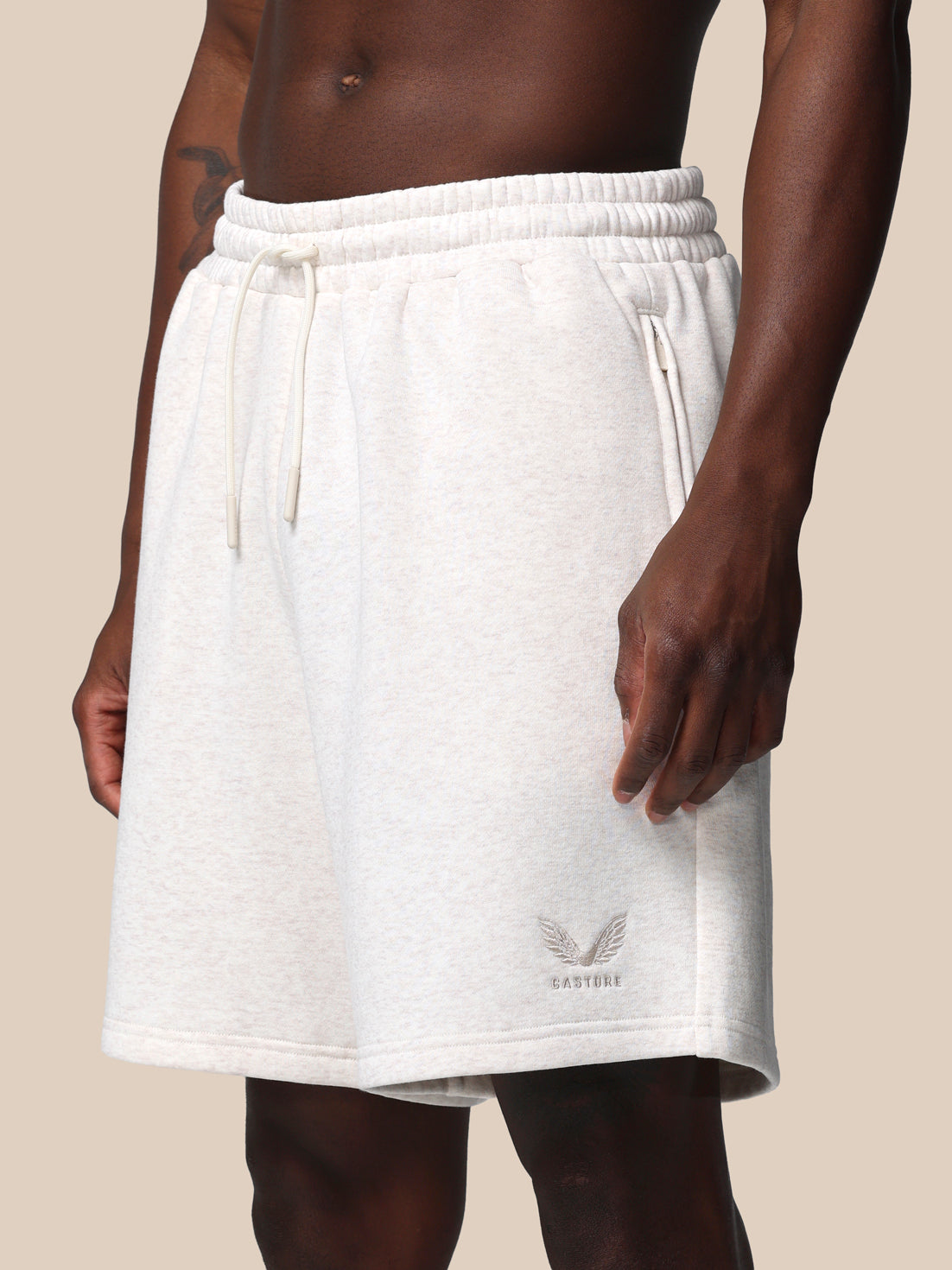 White shorts worn by a person on a beige background