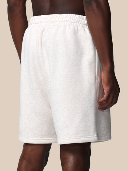 White shorts worn by a person on a beige background