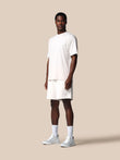 Man wearing a white t-shirt and shorts on a beige background