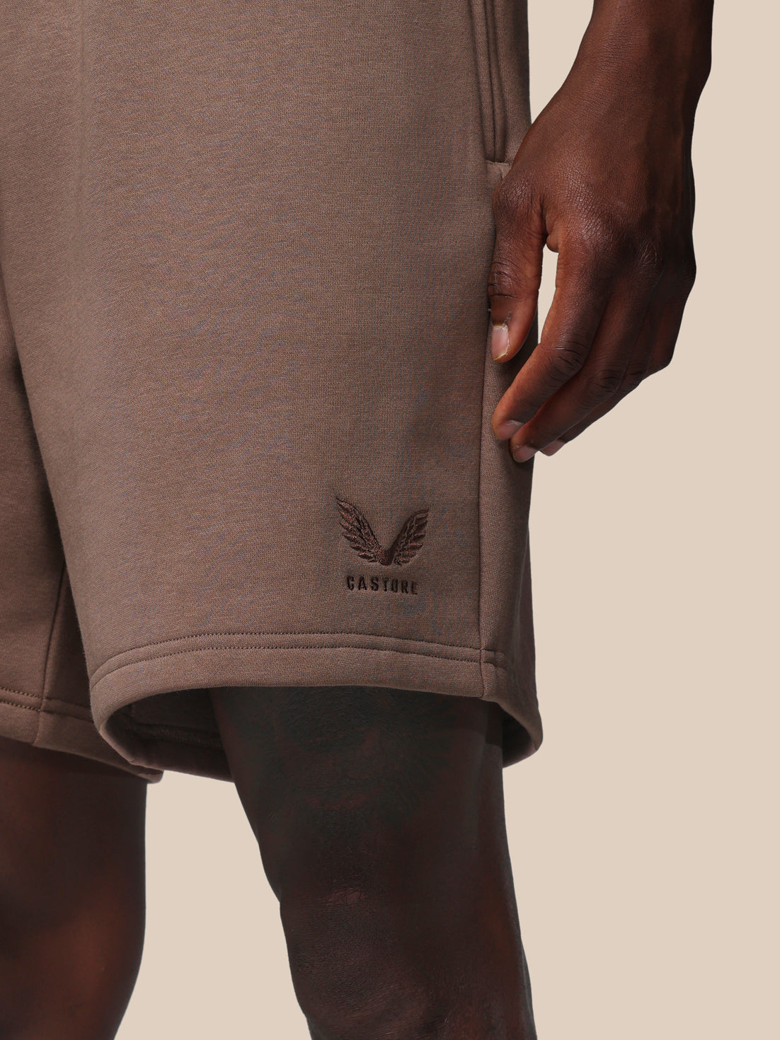 Brown shorts with a logo on a beige background