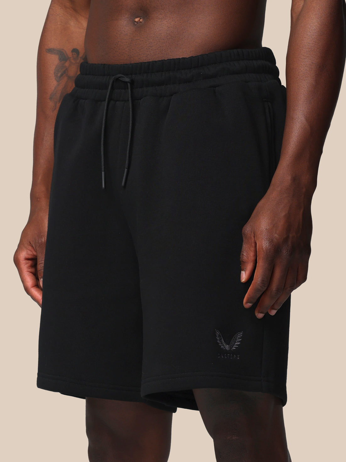 Black shorts with a brand logo on a beige background