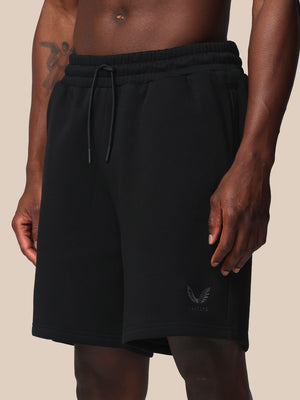 Black shorts with a brand logo on a beige background