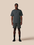 Man wearing a dark gray t-shirt and shorts set on a beige background