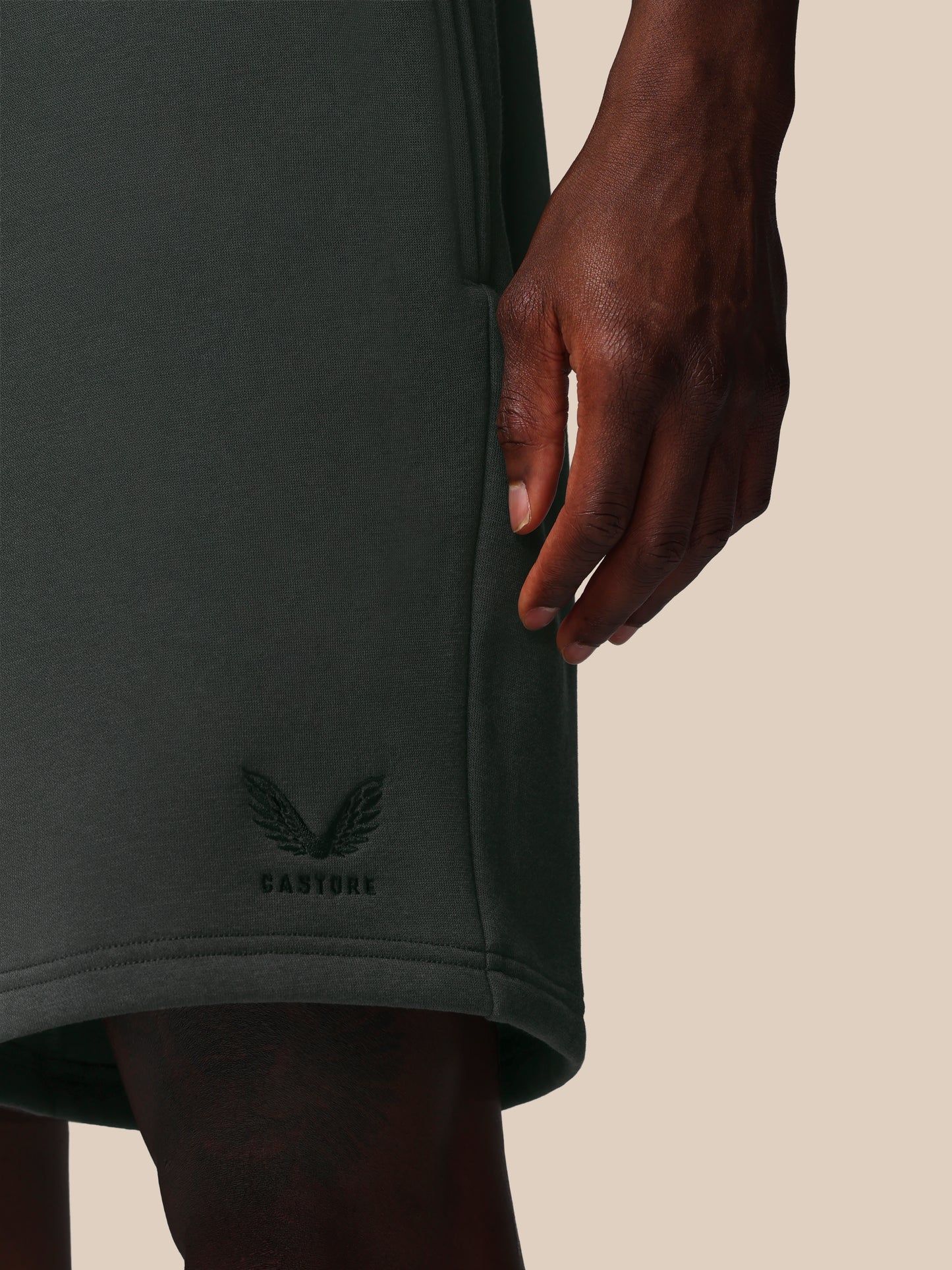Dark gray athletic shorts with a brand logo on a beige background