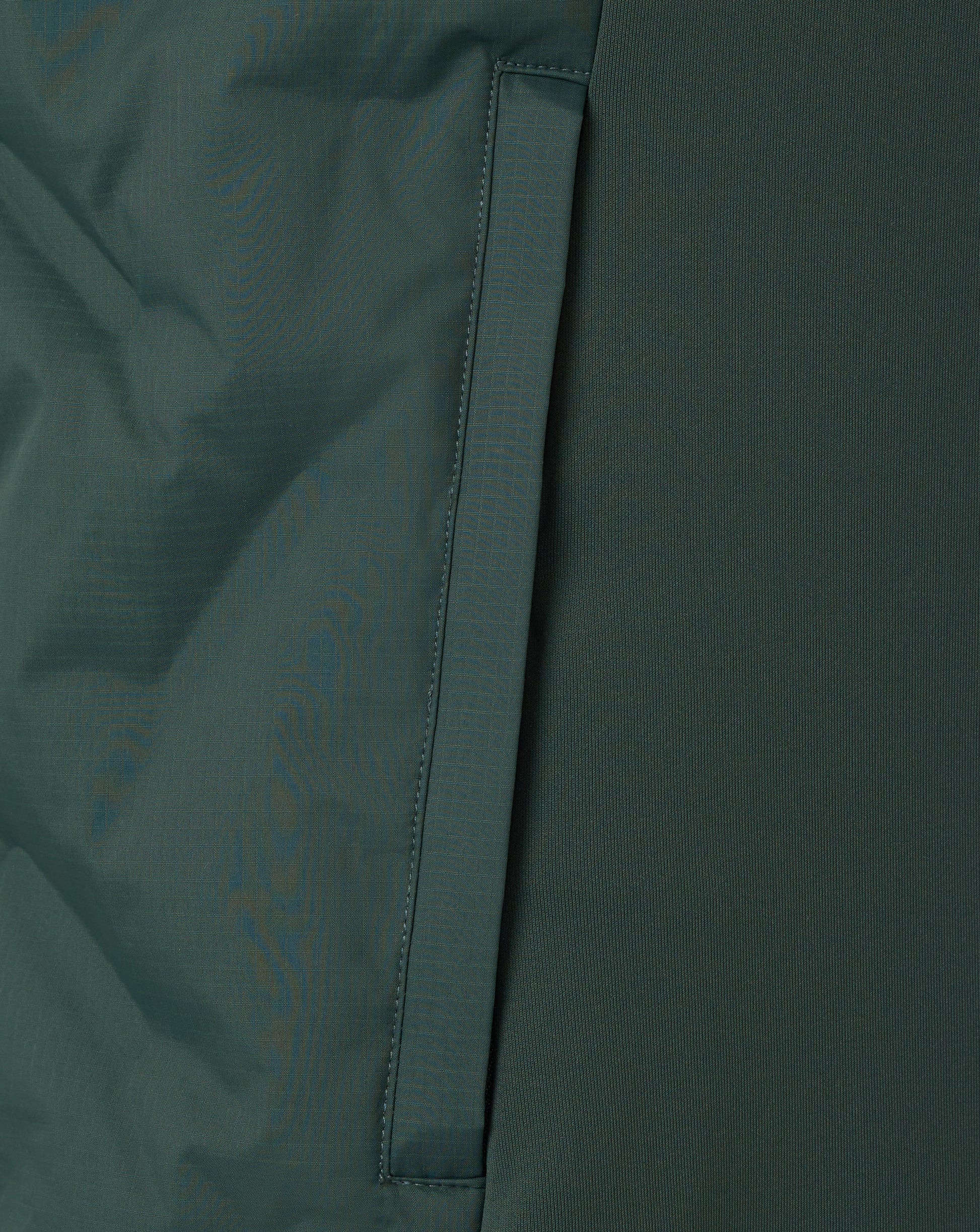 Close-up of a dark green fabric with a visible seam