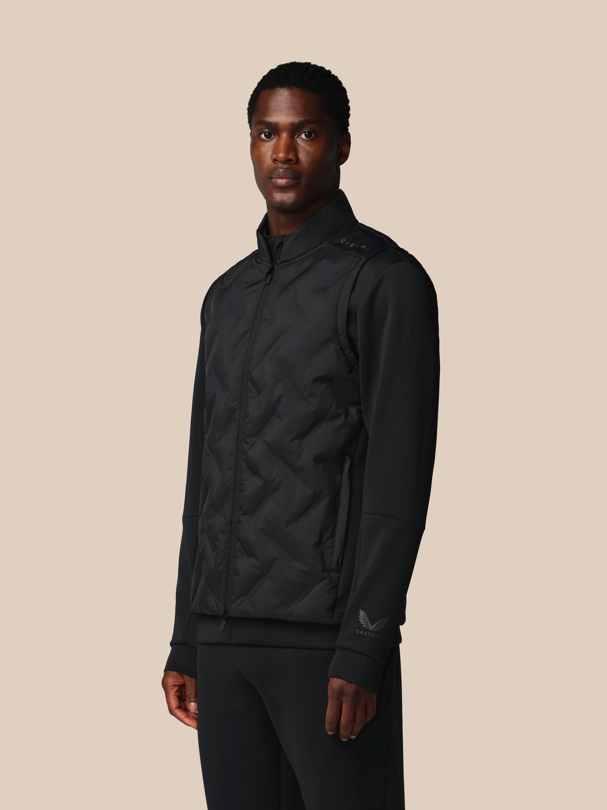 Man wearing a black jacket on a beige background