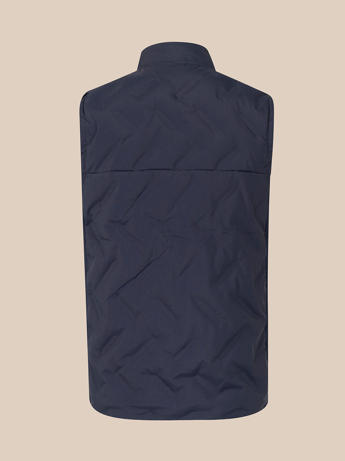 A sleeveless quilted vest in a dark navy blue, shown from the back against a solid beige background.