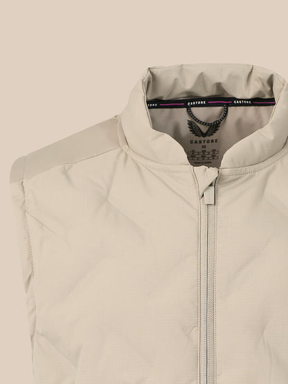 Close-up of a light beige zip-up vest with a stand collar, showing the inner neck label with the brand name Cartagine.