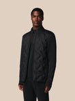 Man wearing a black jacket on a beige background