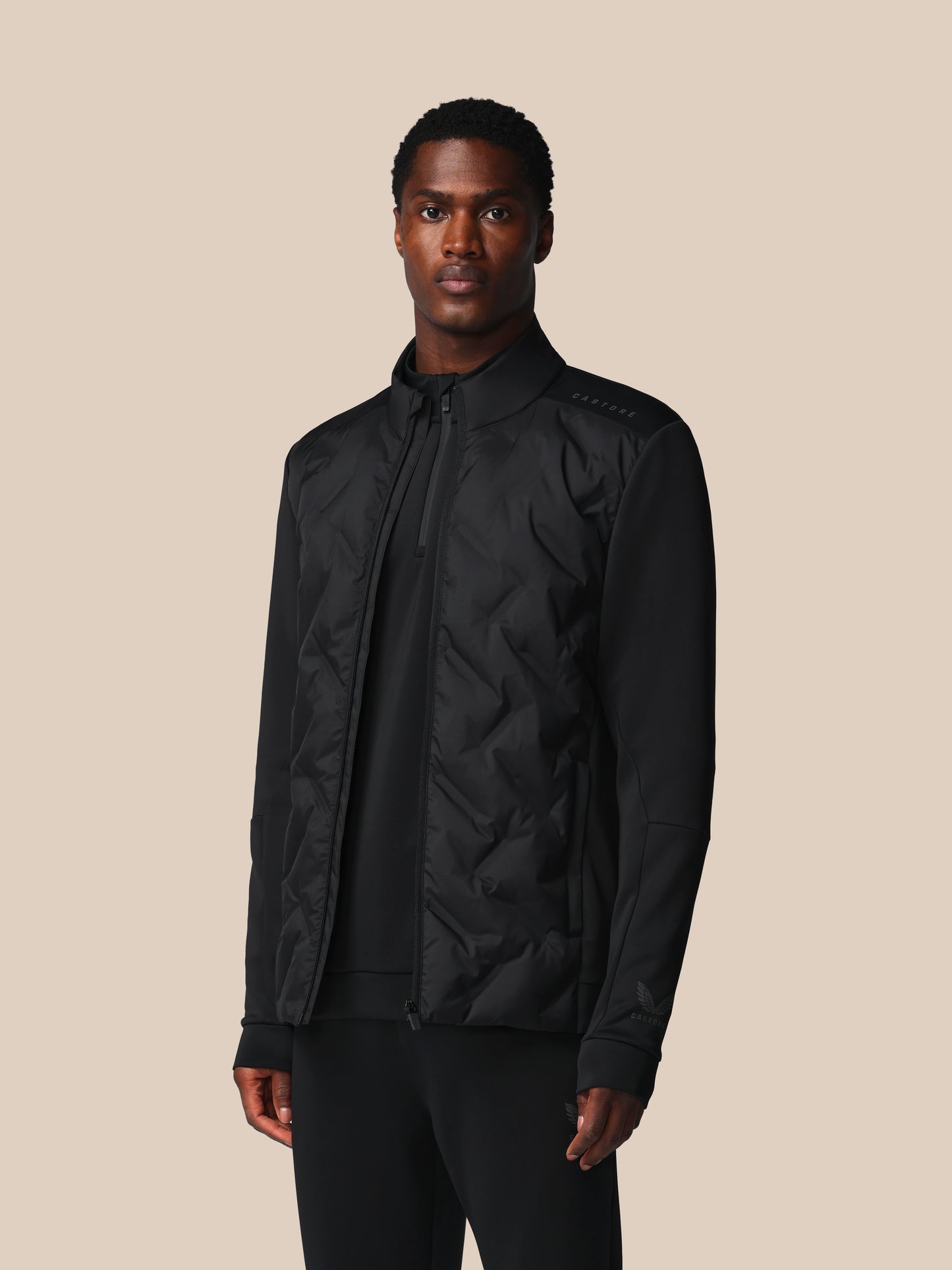 Man wearing a black jacket on a beige background