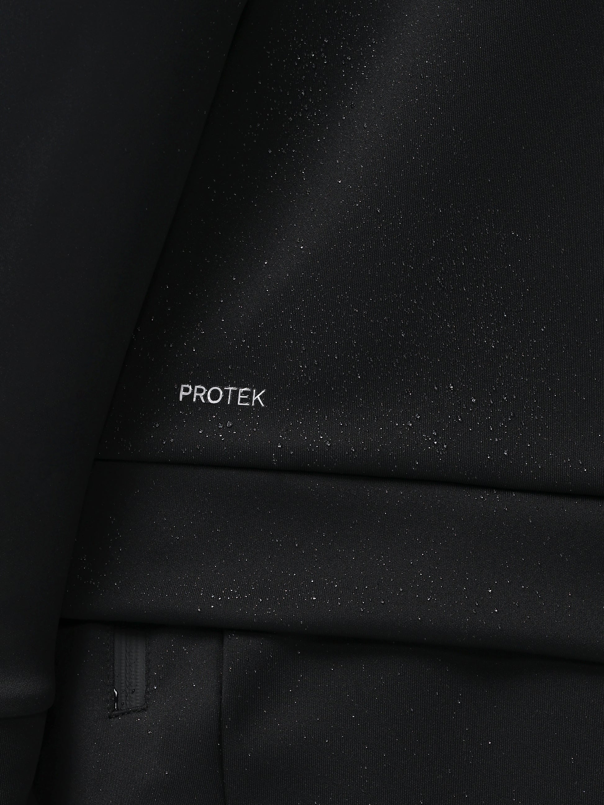 Close-up of a black textured surface with 'PROTEK' branding.