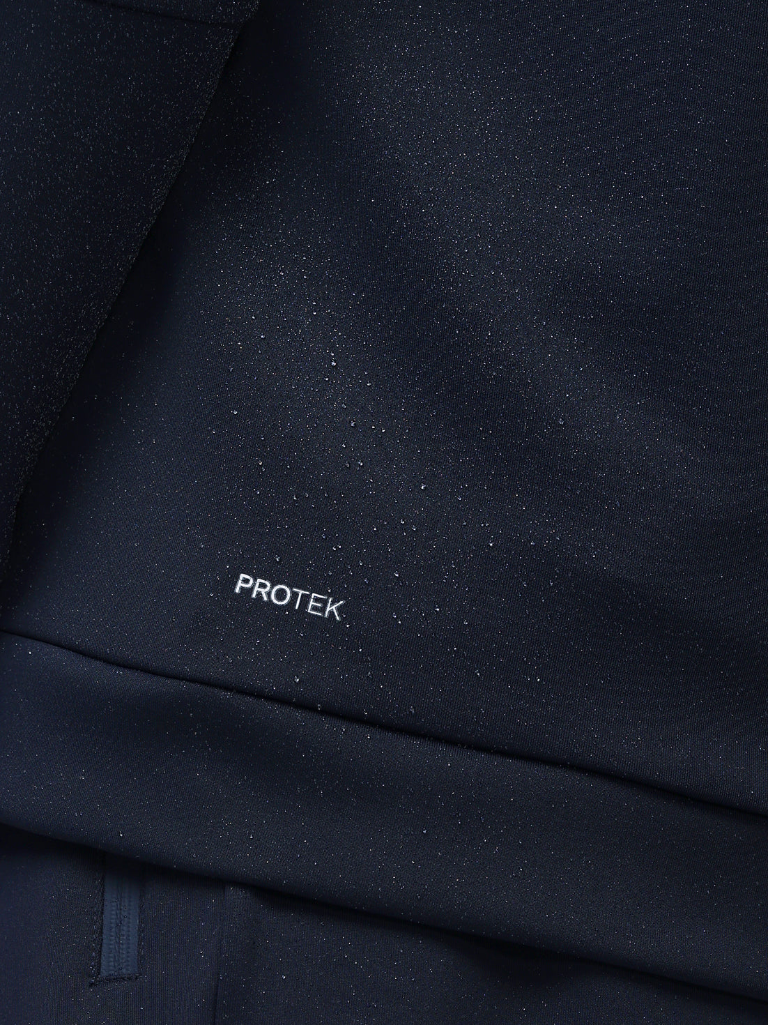 Close-up of dark blue fabric with 'PROTEK' branding.