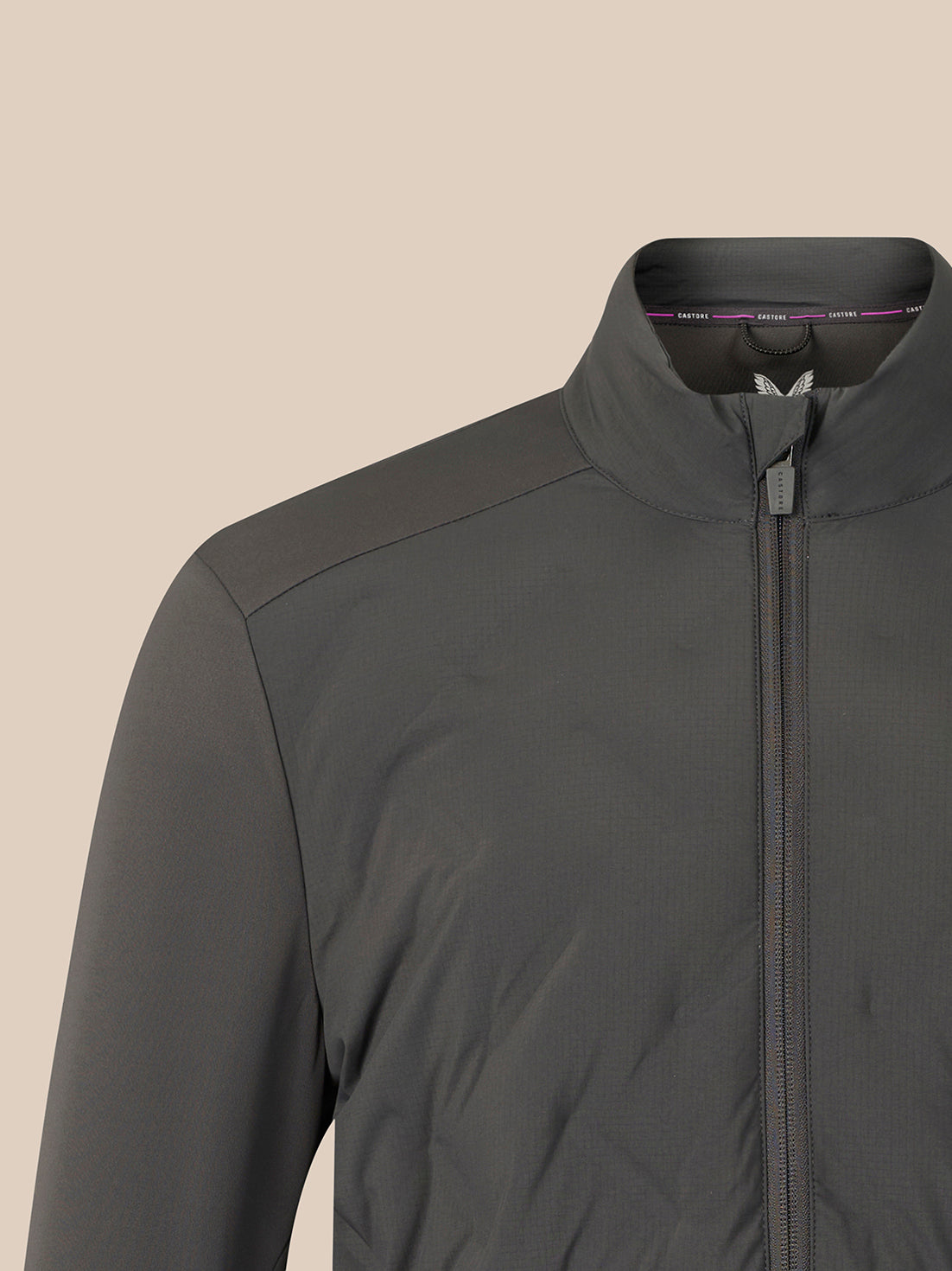 Close-up of a dark gray zip-up jacket with a stand collar, shown on a plain beige background.