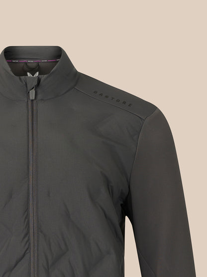 Close-up of a dark gray zip-up jacket with a stand collar and subtle 'CASTORE' branding on the shoulder, set against a solid beige background.