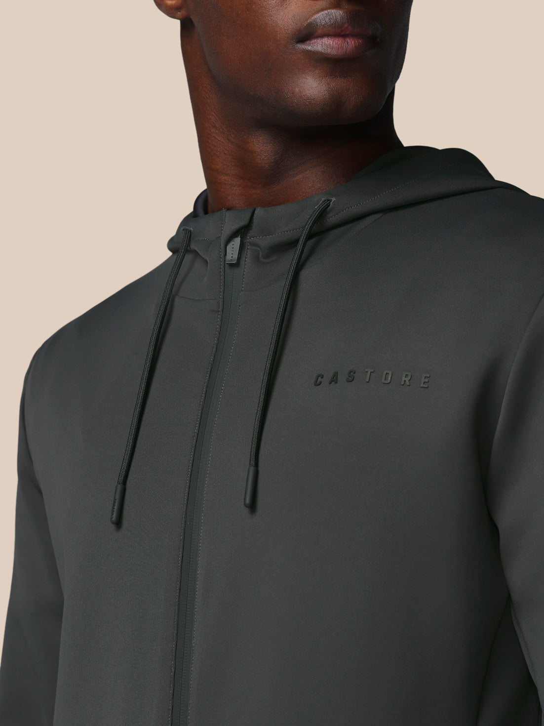 Dark gray hoodie with brand logo on a neutral background