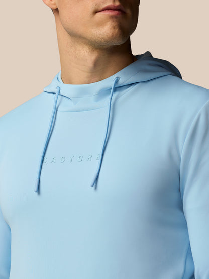 Light blue hoodie with a brand logo on a beige background