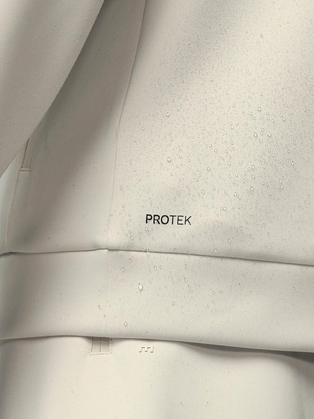 Close-up of a gray fabric with 'PROTEK' branding.