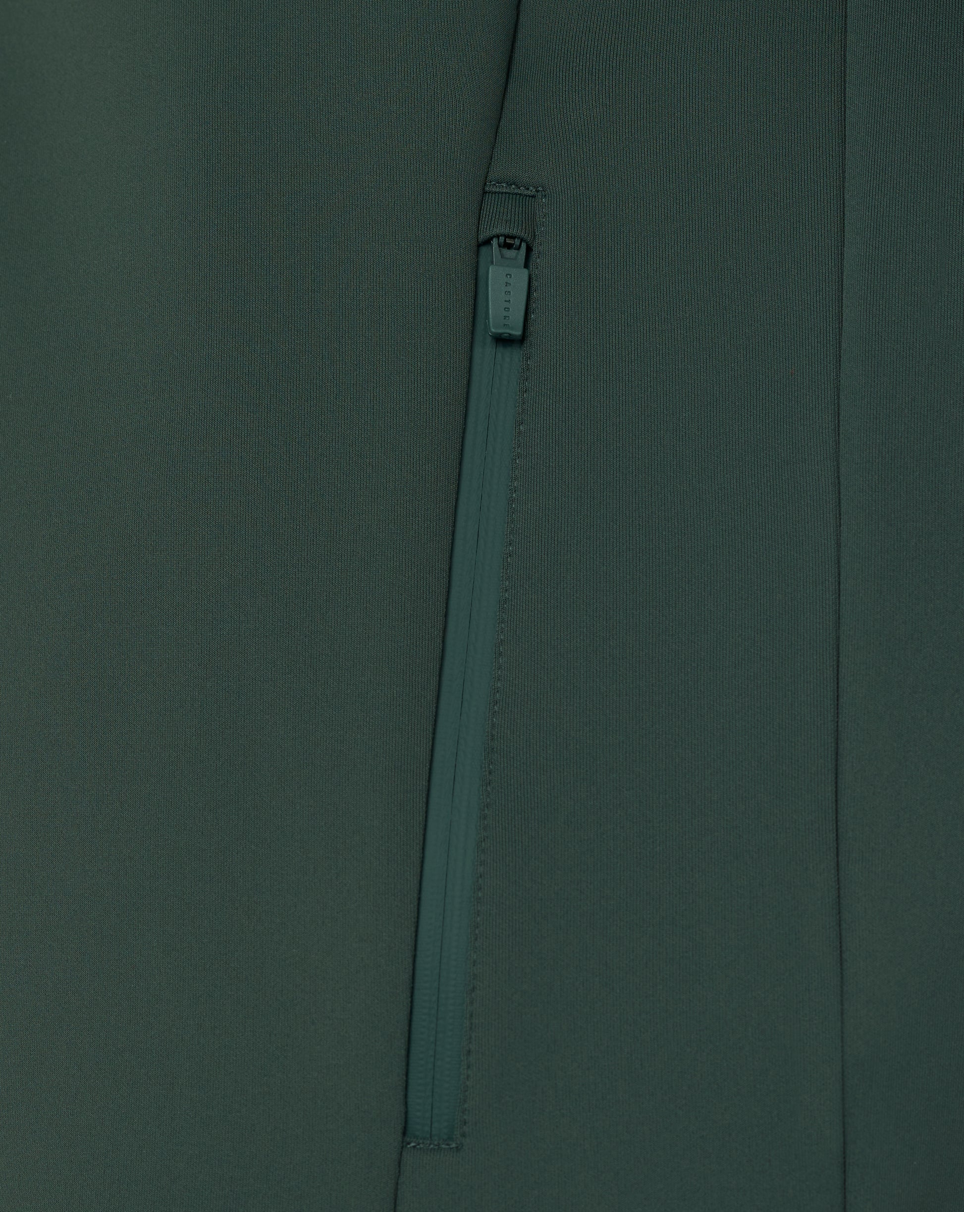 Close-up of a zipper on a dark green fabric background