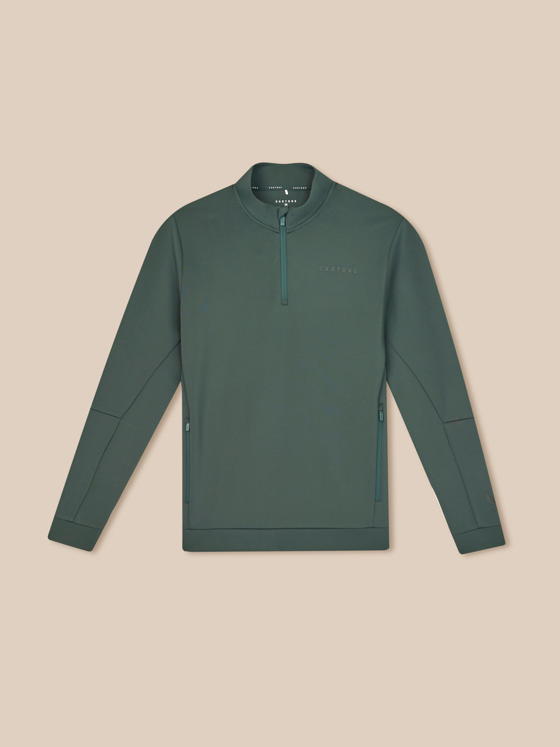 Green long-sleeve shirt with a quarter zip on a beige background