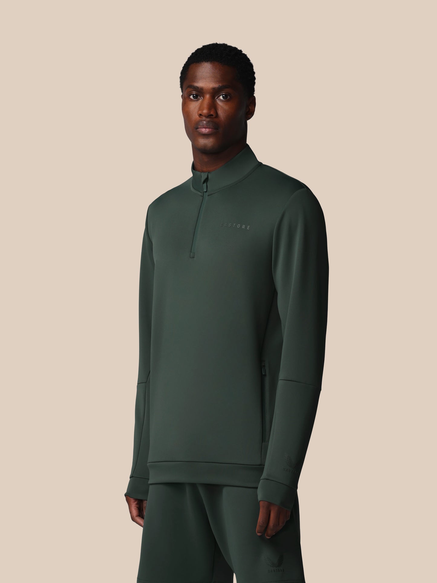 Man wearing a green athletic outfit on a beige background