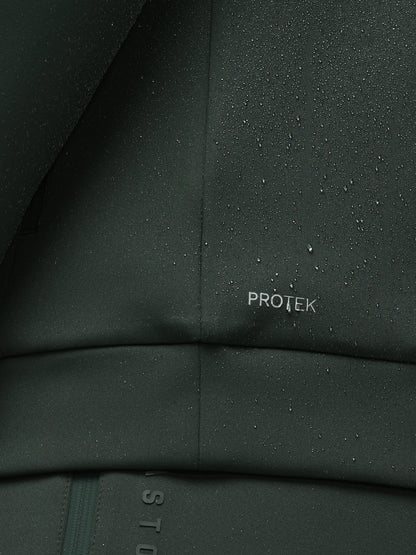 Close-up of a dark green fabric with 'PROTEK' branding, showing water droplets.