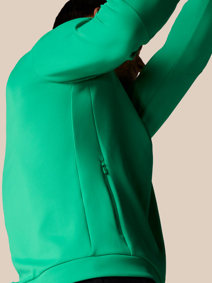Person wearing a green hoodie on a beige background