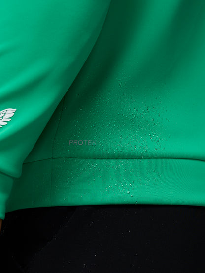 Close-up of a green jacket with water droplets on the fabric, featuring a brand logo.
