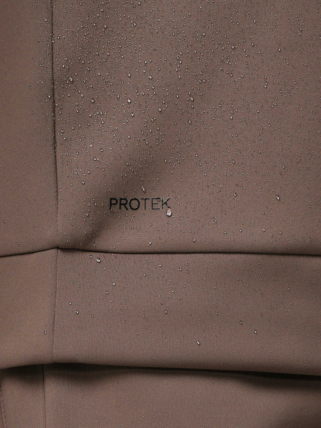 Brown fabric with 'PROTEK' branding and water droplets.