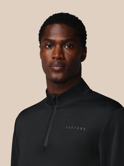 Man wearing a black jacket with 'CASTORE' branding on a beige background