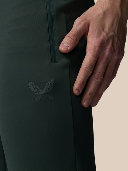 Close-up of a person's hand touching a black jacket with a visible brand logo on a beige background