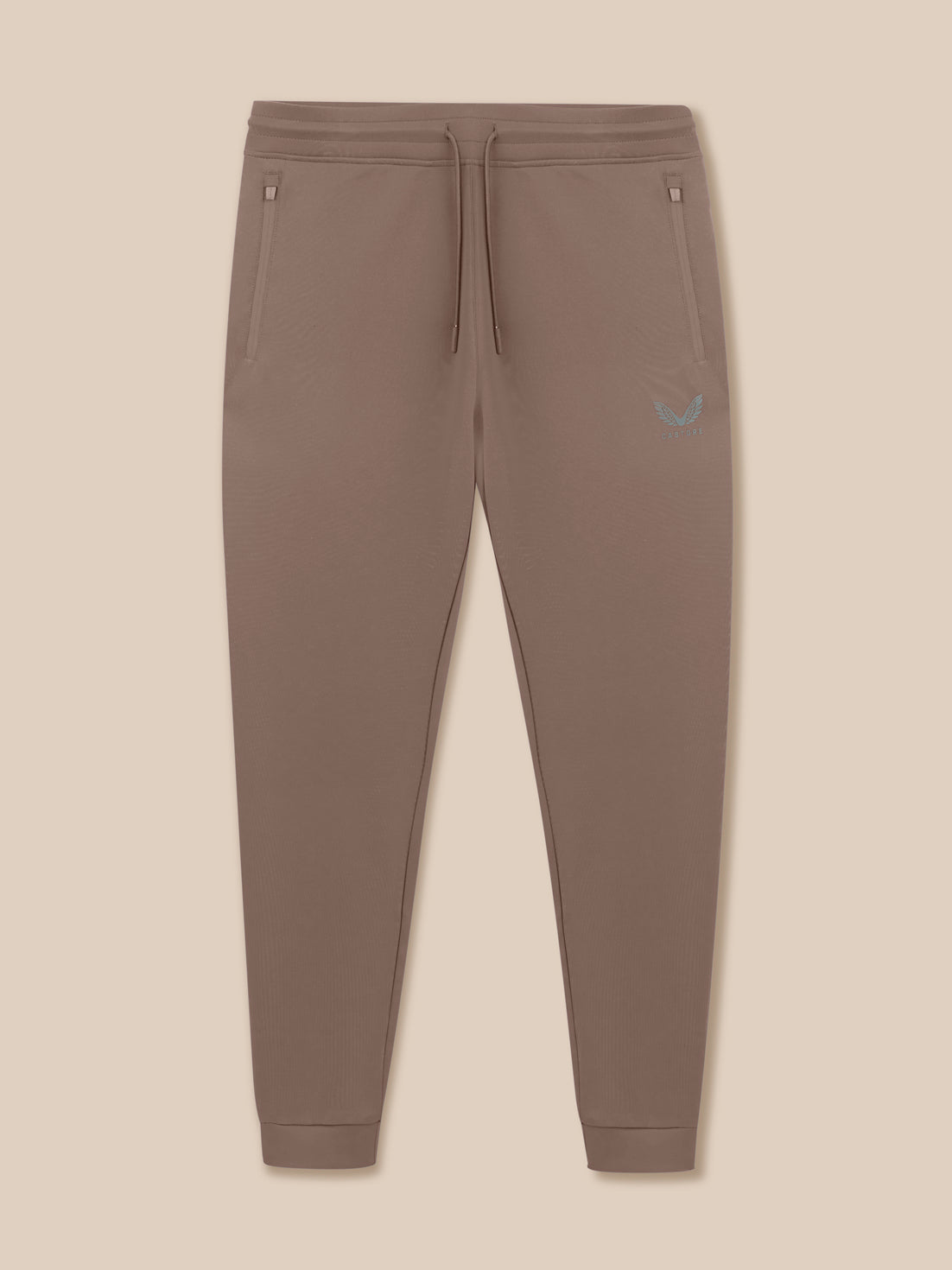 Brown jogger pants with a small logo on a beige background